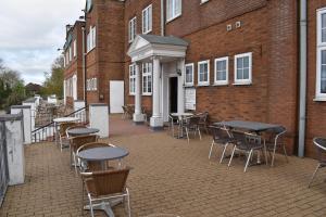 a patio with tables and chairs in front of a building at Quality Hotel Coventry in Coventry