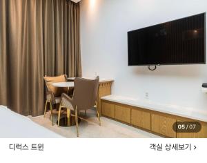 a room with a table and a television on a wall at 호텔뷰 in Tomin-dong