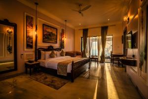 a bedroom with a bed and a living room at Amrutham Bagh Resort & Spa in Udaipur +63 photos