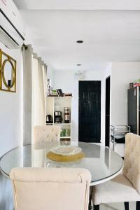 a dining room with a glass table and white chairs at Casa Flores in Sampong