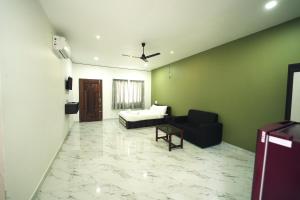 a living room with a bed and a couch at Mountain Breeze Neyyans in Attappādi