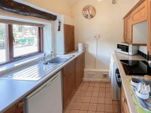 a kitchen with a sink and a microwave at Stable Cottage in Leek +9 photos