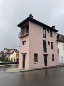 a pink building on the side of a street at Studio confortable à proximité des thermes in Salies-de-Béarn