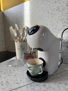 a coffee maker on a counter with a cup of coffee at Studio confortable à proximité des thermes in Salies-de-Béarn