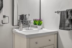 a bathroom with a white sink and a mirror at 17th Ave Cozy Place in DT, short walk to Calgary Stampede in Calgary +27 photos