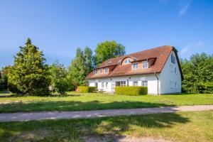 a white house with a red roof at BSW Ferienwohnungen Hiddensee in Hiddensee