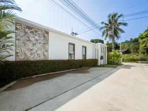 a white building with a mural on the side of it at Calypso Villa Phuket - Naiyang Beach in Nai Yang Beach