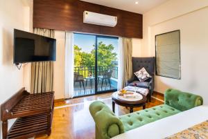 a living room with a couch and a television at Amrutham Bagh Resort & Spa in Udaipur