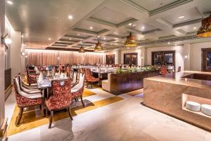 a restaurant with tables and chairs and a bar at Amrutham Bagh Resort & Spa in Udaipur