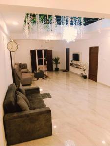 a living room with a couch and a clock on the wall at Shans Valley in Kotagiri