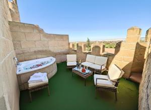 a balcony with a tub and chairs and a table at Hotel Castillo Bonavía in Pedrola