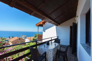 a table on a balcony with a view of the ocean at Apartment DiLen in Dobra Voda