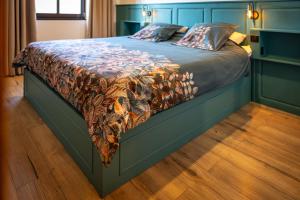 a bedroom with a bed with a blue headboard at Fank'House in Guémar