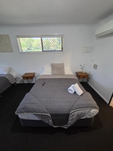 a bedroom with a large bed with two chairs and a window at Agnes Palms Motel in Agnes Water +85 photos