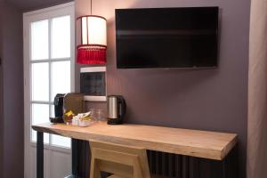 Una mesa en una habitación con un televisor en la pared. en Piccola Torre Maison, en Vigevano