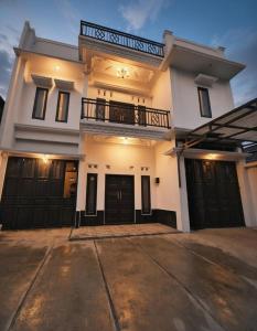 a large white house with black garage doors at Altea House in Diyeng