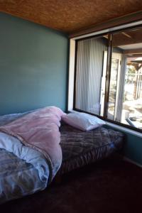 a bed sitting in a room with a window at 民泊 福来 in Nasushiobara