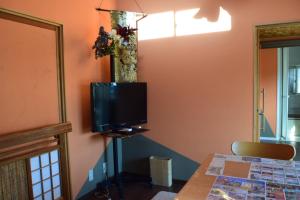 a living room with a tv on the wall at 民泊 福来 in Nasushiobara