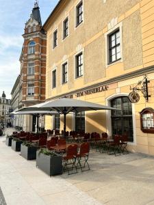 a restaurant with tables and chairs in front of a building at Hotel Wilder Mann Annaberg-Buchholz in Annaberg-Buchholz