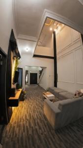 a large living room with a couch and a tv at Altea House in Diyeng