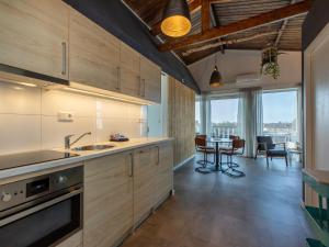 a kitchen with wooden cabinets and a dining room at Lovely, modern, 4-person apartment in the heart of Koudekerke in Koudekerke