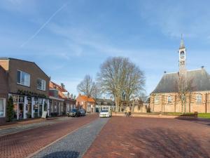 a street in a small town with a clock tower at Lovely, modern, 4-person apartment in the heart of Koudekerke in Koudekerke