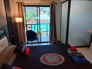 a bedroom with a bed with a view of a balcony at Hi Karon Beach in Karon Beach
