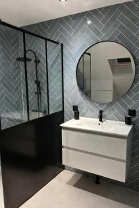 a bathroom with a white sink and a mirror at Au papillon des coteaux in Magenta