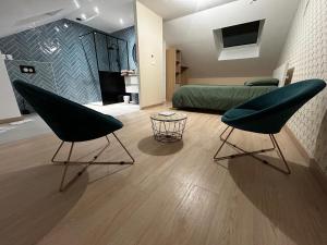 a room with a bed and two chairs in it at Au papillon des coteaux in Magenta