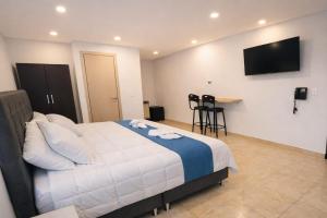 a bedroom with a bed and a television on the wall at Aparta Estudios Luz Galery in Bogotá