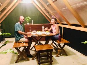 a man and woman sitting at a table with food at Elephant Cabana Udawalawe in Udawalawe +28 photos