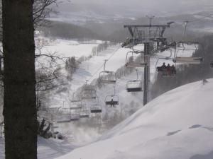 a group of people riding a ski lift in the snow at Apartman Flora in Benecko
