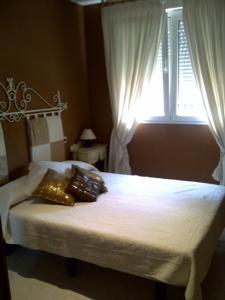 1 dormitorio con 1 cama con ventana y almohadas en Apartment Martinez Cala Josep, en Alcossebre