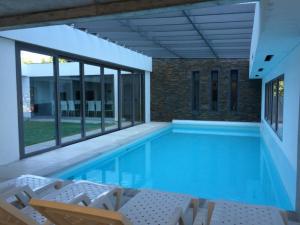 a large swimming pool with chairs and a building at Apartamento Chronos in Punta del Este +19 photos