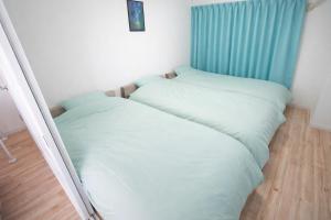 two beds sitting next to each other in a room at マンションルミエールＩ301 rumiereＩ301 in Gifu
