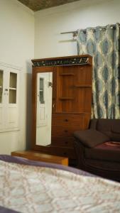 a bedroom with a dresser and a couch and a mirror at Burj Resort in Ban