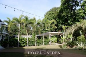 a hotel garden with palm trees and a building at Hotel Siena in Sampong