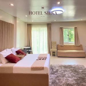 a hotel bedroom with a large bed and a couch at Hotel Siena in Sampong