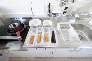 a kitchen counter with utensils in a sink at マンションルミエールＩ301 rumiereＩ301 in Gifu