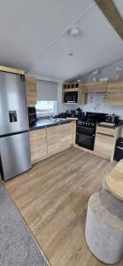 a large kitchen with wooden floors and stainless steel appliances at 8 berth 3 Bedroomed CARAVAN Lyons Robin Hood Rhyl 17 Elm Crescent in Meliden