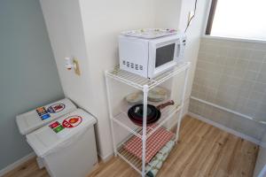 a microwave sitting on a shelf in a bathroom at マンションルミエールＩ301 rumiereＩ301 in Gifu