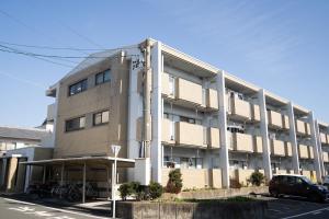 an apartment building with a car parked in front of it at マンションルミエールＩ301 rumiereＩ301 in Gifu