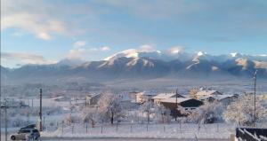 a snow covered city with mountains in the background at Villa Detelina near the Bansko Ski Resort with Jacuzzi in Razlog