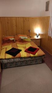 1 dormitorio con 1 cama grande con sábanas amarillas y rojas en Napsugár Vendégházikó en Orosháza
