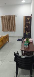 a room with a table and a chair with flowers on it at Shri Lawn Park in Sīrkāzhi
