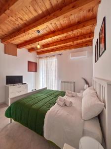 a bedroom with a large bed with a green blanket at Casa Vacanza Nì Rosa in Cefalù