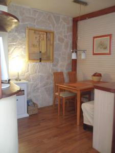 cocina con mesa, sillas y pared de piedra en Apartment Lili, en Šibenik