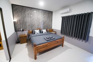 ein Schlafzimmer mit einem Bett in einem Zimmer in der Unterkunft บ้านคุณ เฮ้าส์ in Phrae