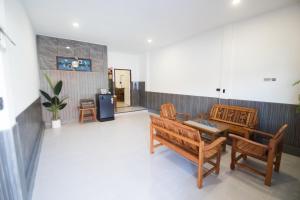 ein Raum mit zwei Holzbänken und einem Tisch in der Unterkunft บ้านคุณ เฮ้าส์ in Phrae