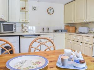 a kitchen with a table with a plate on it at Swallow Cottage in Leek